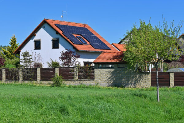 Casă cu panouri solare pe acoperiș și grădină